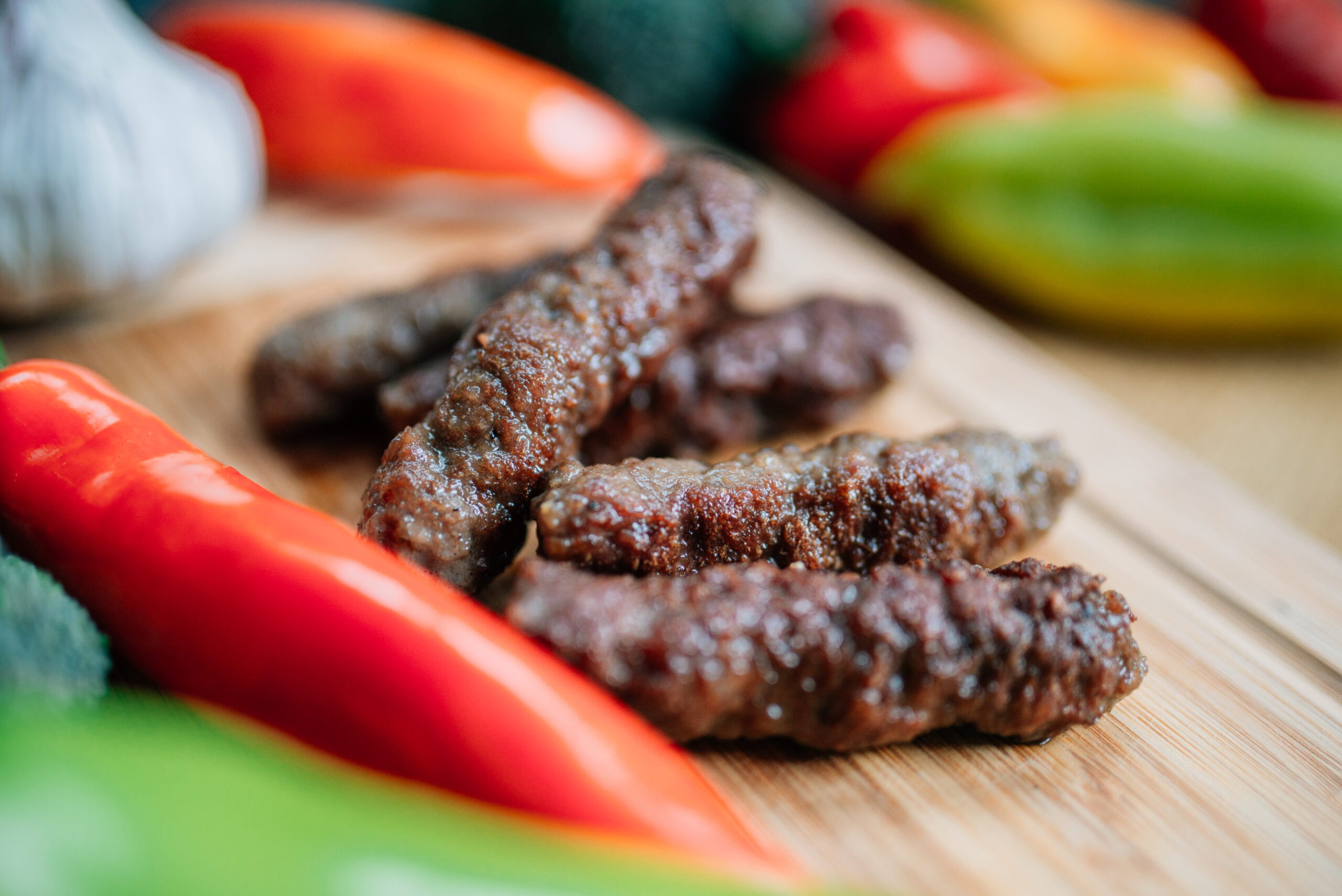 Ćevapčići: Piccole salsicce di carne macinata (spesso manzo e agnello), grigliate e servite con cipolla. 